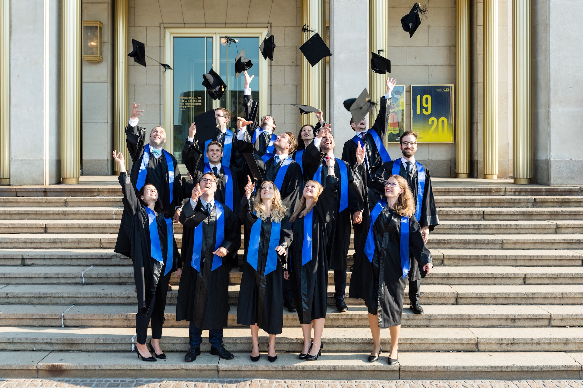 Doctoral graduates throwing their hats into the air